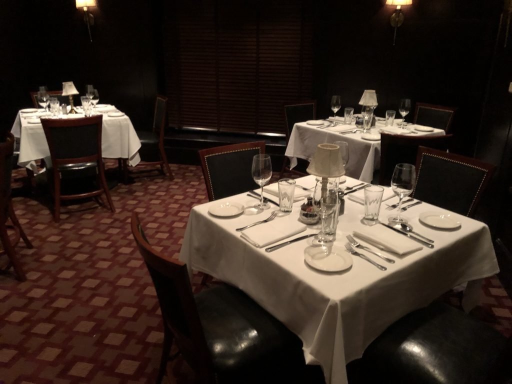 Salão de restaurante com mesas, talheres e pratos em Miami 