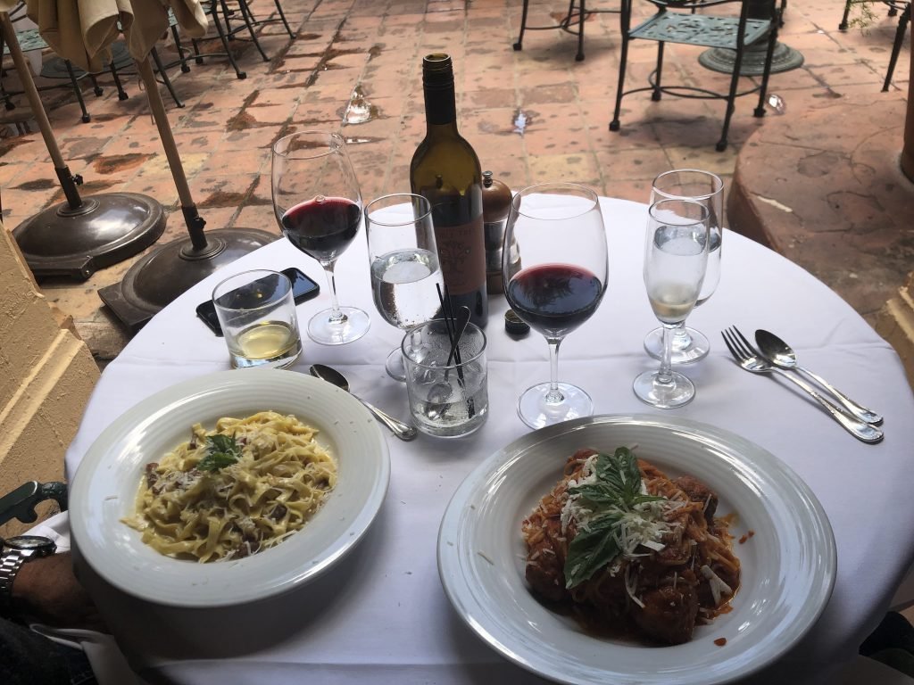 Mesa com dois pratos de comida e taças de vinho cheias em Miami 