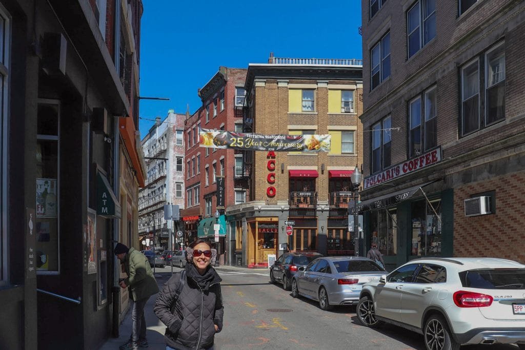 Mulher sorrindo em frente a restaurante no North End, em Boston 